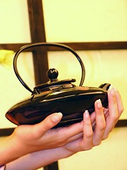 Image showing Female hands and teapot