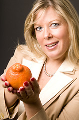 Image showing attractive blond woman with mineola orage tangerine  fruit for h