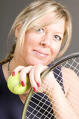 Image showing happy smiling female tennis player with racquet and ball healthy