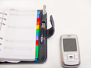 Image showing Office objects - Pen diary and a cell phone
