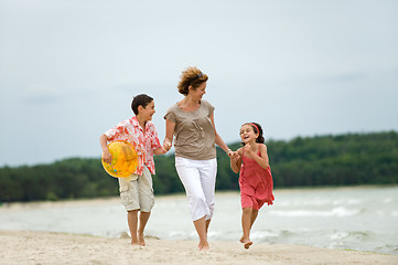 Image showing Mother and kids walking on the beach