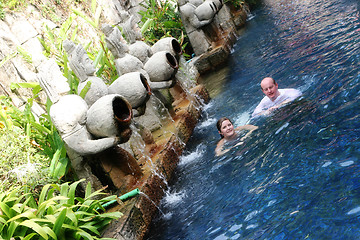 Image showing Couple swimming under Thai statues.