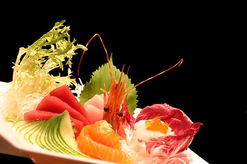 Image showing Assortment of sushi on a plate against a black background.