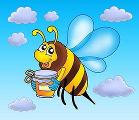 Image showing Flying bee holding honey