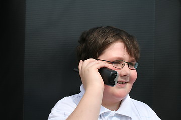 Image showing Cute young boy talking on the telephone