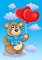 Image showing Teddy bear with heart balloons on blue sky