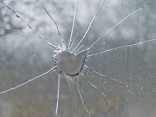 Image showing Big hole in cracked glass