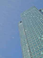 Image showing Green skyscraper and jet plane