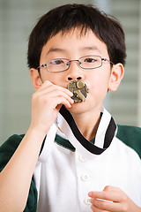 Image showing Winning boy kissing medal