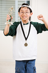 Image showing Winning boy with his medal and trophy