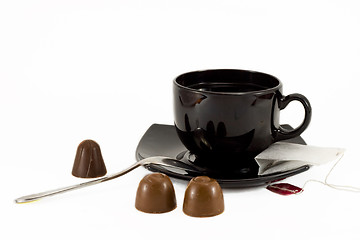 Image showing Tea cup, teaspoon and chocolates isolated