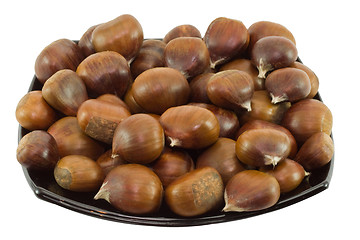 Image showing Chestnuts on dark plate isolated on white background