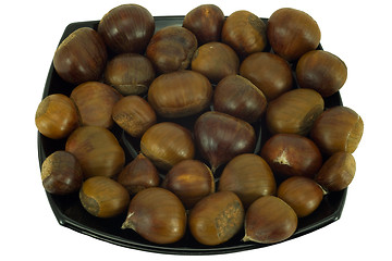 Image showing Chestnuts on dark plate isolated on white background