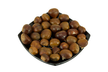 Image showing Chestnuts on dark plate isolated on white background