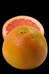 Image showing Couple halfs of grapefruit isolated on black background