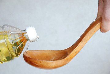 Image showing Pouring oil in wooden spoon