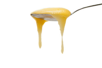 Image showing Iron spoon flowing down honey