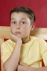 Image showing Sitting boy resting head on hand