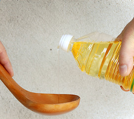 Image showing Pouring oil into wooden spoon