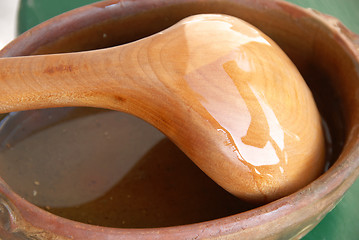 Image showing Wooden spoon in earthenware
