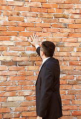 Image showing Businessman by brick wall