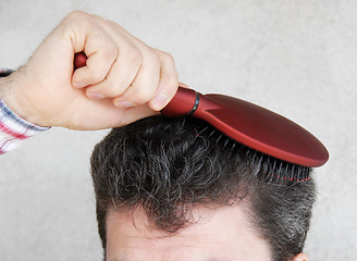 Image showing Man brushing hair