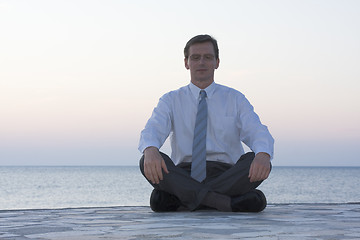 Image showing Businessman meditating by the sea