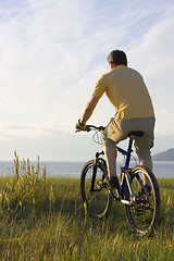 Image showing Man riding bicycyle at the sea