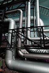 Image showing industrial pipelines on pipe-bridge against blue sky    