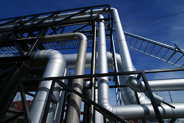 Image showing industrial pipelines on pipe-bridge against blue sky   