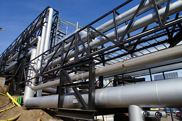 Image showing industrial pipelines on pipe-bridge against blue sky   