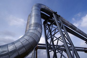 Image showing industrial pipelines on pipe-bridge against blue sky   