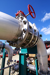 Image showing industrial pipelines on pipe-bridge against blue sky   