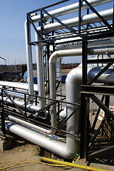 Image showing industrial pipelines on pipe-bridge against blue sky 