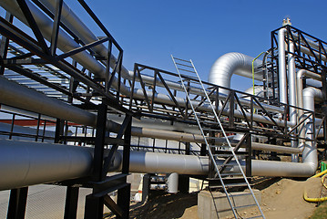 Image showing industrial pipelines on pipe-bridge against blue sky 