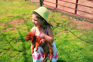 Image showing Young girl holding puppy