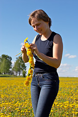 Image showing woman twining a dandelion wreath