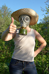 Image showing woman in gas-mask at garden work