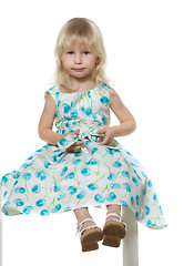 Image showing small blond girl sits on white chair