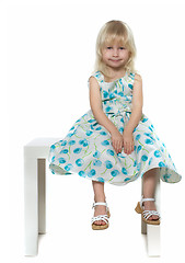 Image showing small blond girl sits on white chair