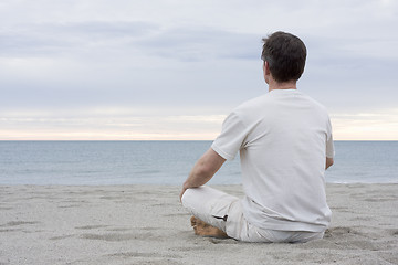 Image showing Man meditating on beach