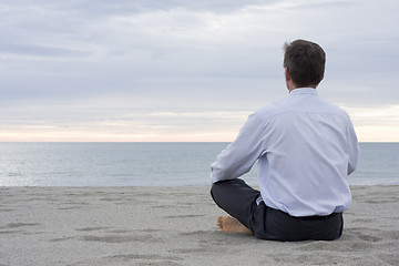 Image showing Businessman meditating at the sea