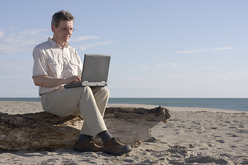 Image showing Man working with laptop on beach