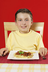 Image showing Child at table with plate of food