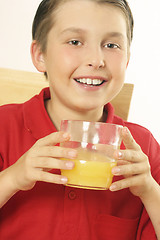 Image showing A child drinking orange juice