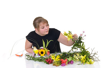 Image showing Young girl arranging flowers 