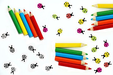 Image showing Multicolored crayons and ladybirds composition