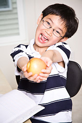 Image showing Studying kid holding an apple