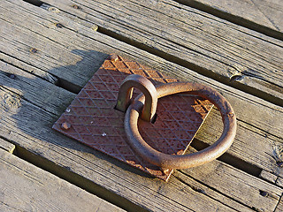 Image showing Rusty iron ring on boards