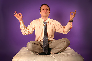 Image showing Young businessman meditating on sofa